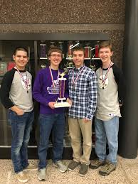 One of the knowledge bowl teams holding the trophy in front of the knowledge bowl trophy case