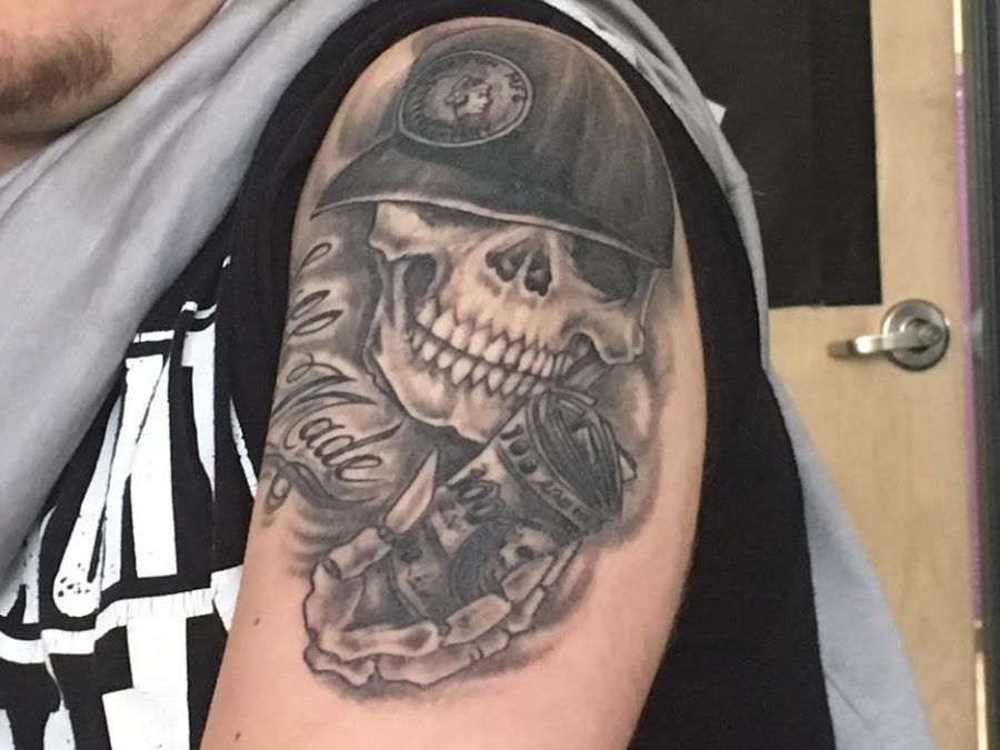 Senior Dylan Nelson flexes his new tattoo with a skull and saying of self made