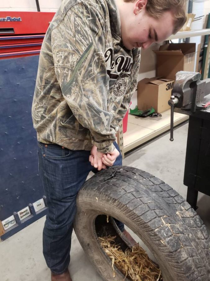 Student Isaac Schwarz patching his tire in Intro to Mechanics class