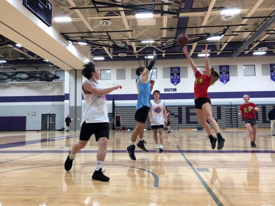 Ally Steffensmeier attempts to shoot a 3-pointer at intramural basketball. Noah Hauge watches in disbelief. 