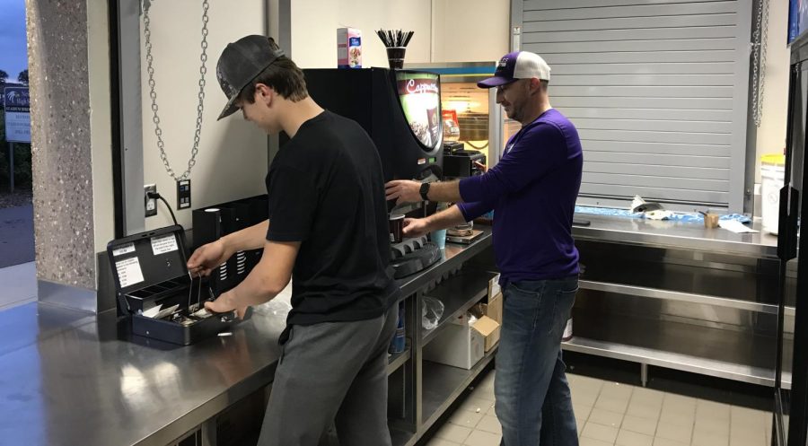 Wesley Grob and varsity hockey coach Ryan Neuman running concessions on Tuesday at the soccer game 