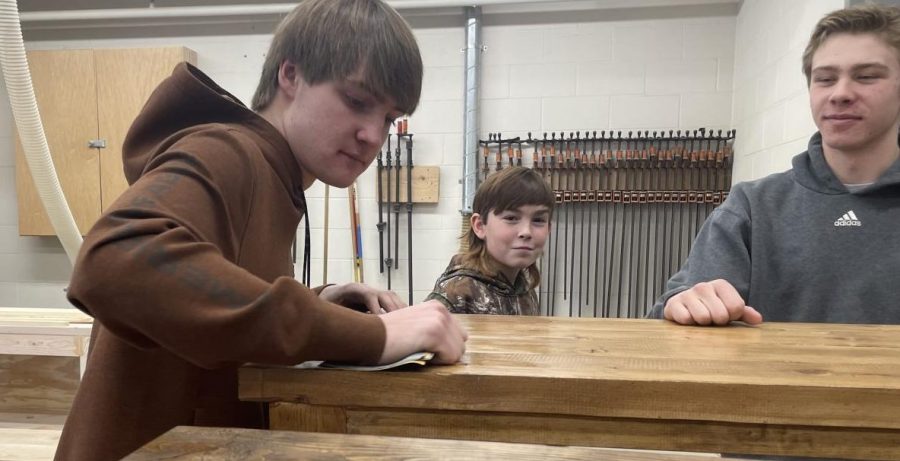 Junior Tyler Whitney is sanding his table in basic woods class