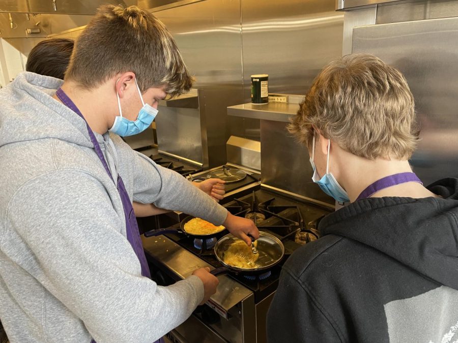 Seniors Dylan Carreon and Jace Schaefer  cooking up omelettes in basic foods recently.