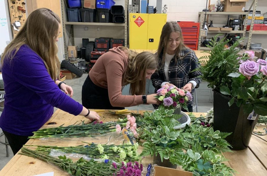 Seniors Emma Neet, Sydney Marquardt, and Haley Hesse prepare flower arrangements for mothers day.  