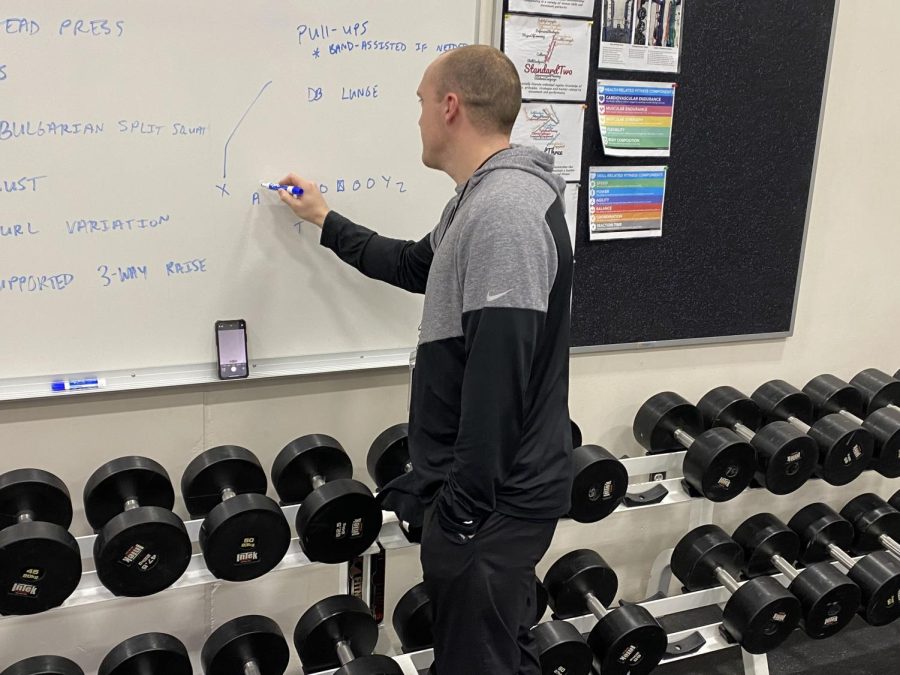 Mr. Lieser, the future head coach for New Ulm Publics football team, draws a football play on the board during his strength and conditioning class.