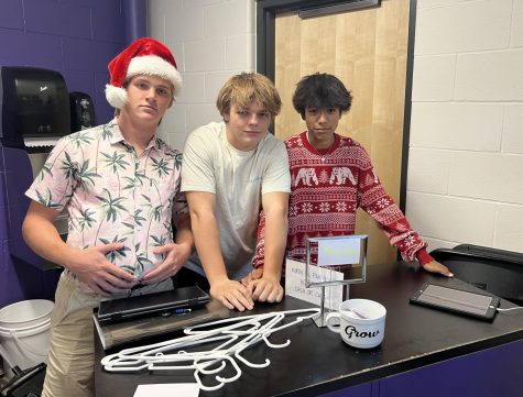 Freshmen Cole Frederick (left), Jackson Ocampo (right), and sophomore Henry Waloch (middle) pose for Holiday Day in the school store on Tuesday, September 20. Frederick, Ocampo, and Waloch are students in Intro to Business, meaning they help run the school store. 