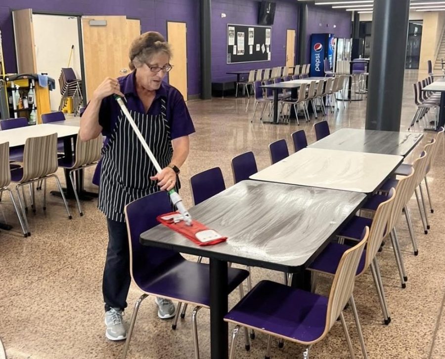 Woman cleans table.