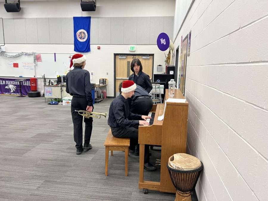 Band members Ian Schotzko (Left), Dain Barie (Seated) and Sam Chalakov (Standing) warm up before the Winter concert on December 12, 2022.