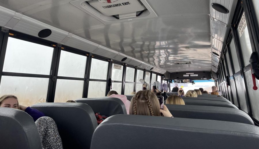 Girls basketball gets ready as they ride the bus for their first away game in Hutchinson on December 8, 2022. Many students did school work, as others enjoyed their time with the team before the big game. 