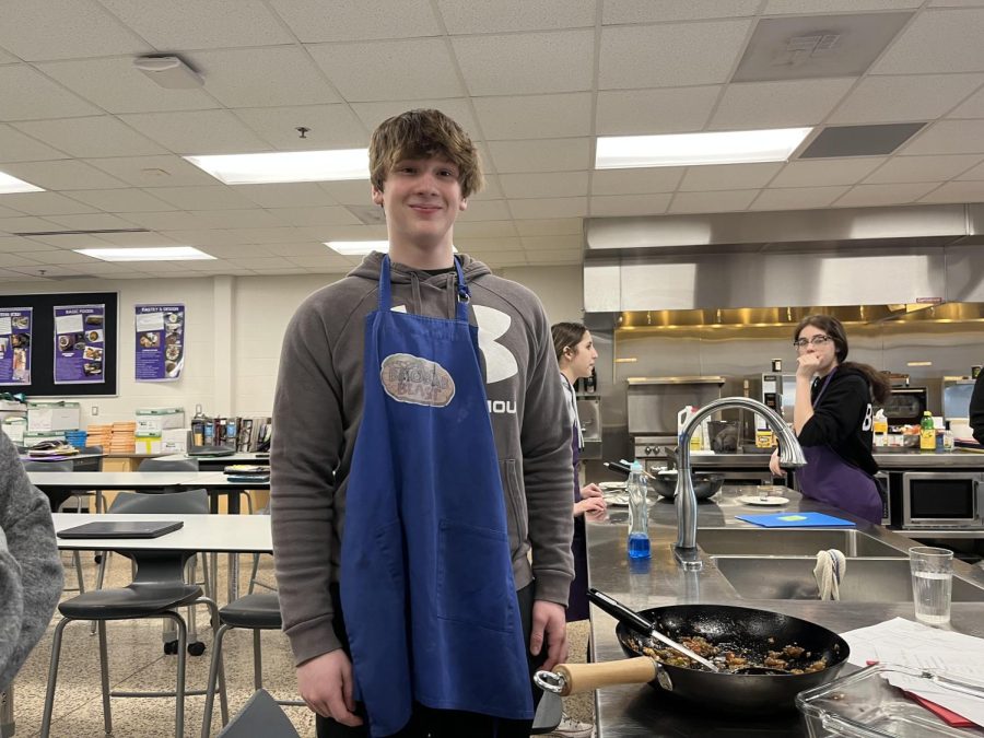 Deegan Tauer standing next to his stir fry in Basic Foods class.