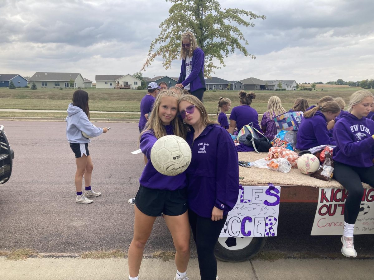 Juniors Kaelyn Eikanger(left) and Paisley Kamrath(right) pose for a picture while getting the NUHS girls soccer float ready for the homecoming parade.