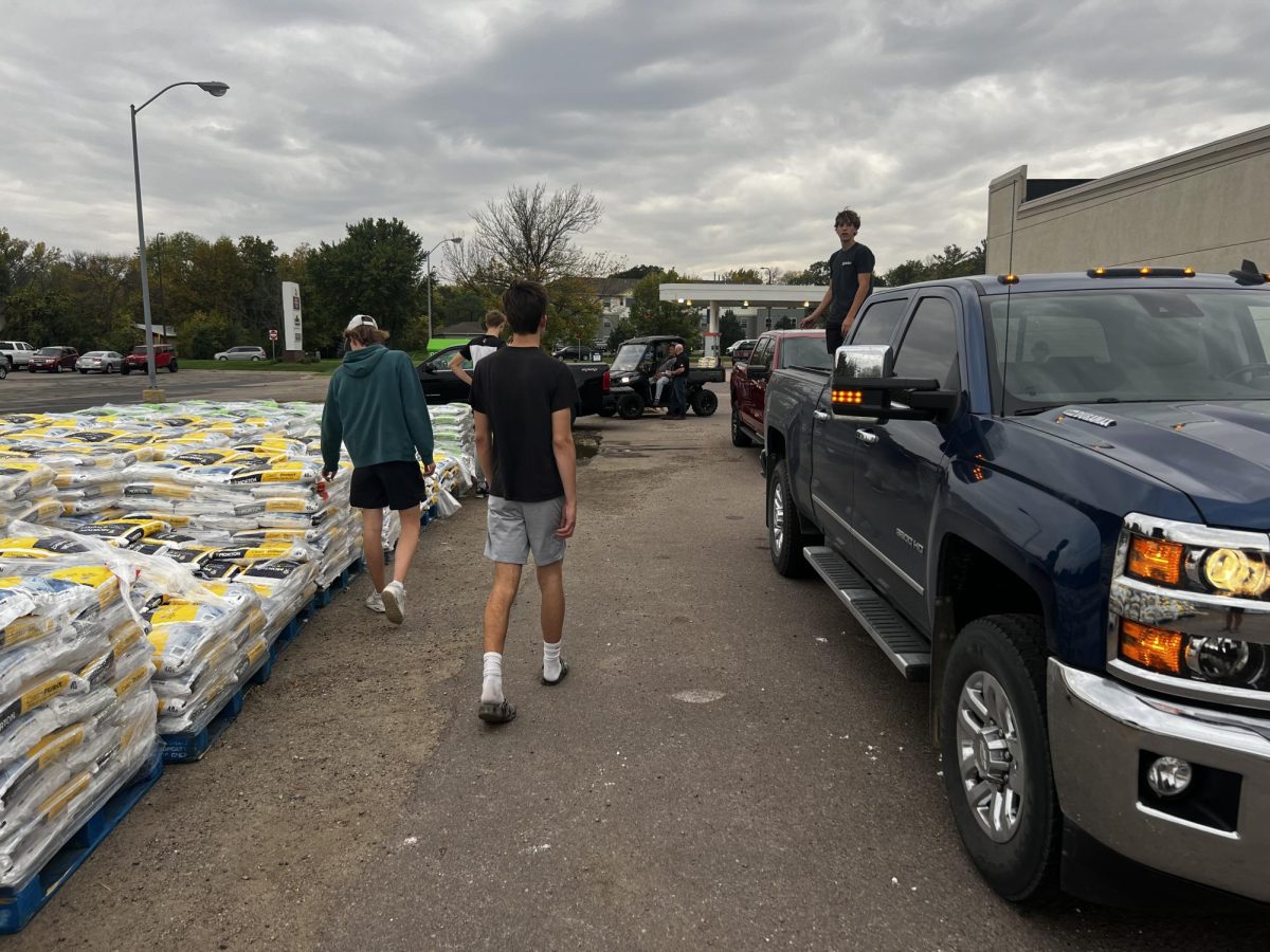 New Ulm basketball and golf athletes help load salt from the fundraiser for the New Ulm Booster Club at Hyvee Tuesday night. 