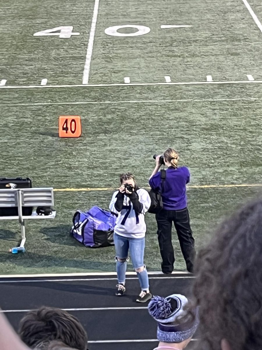 Sohpia Furth (right) and Jaden Jay taking pictures for Yearbook during the homecoming game. 