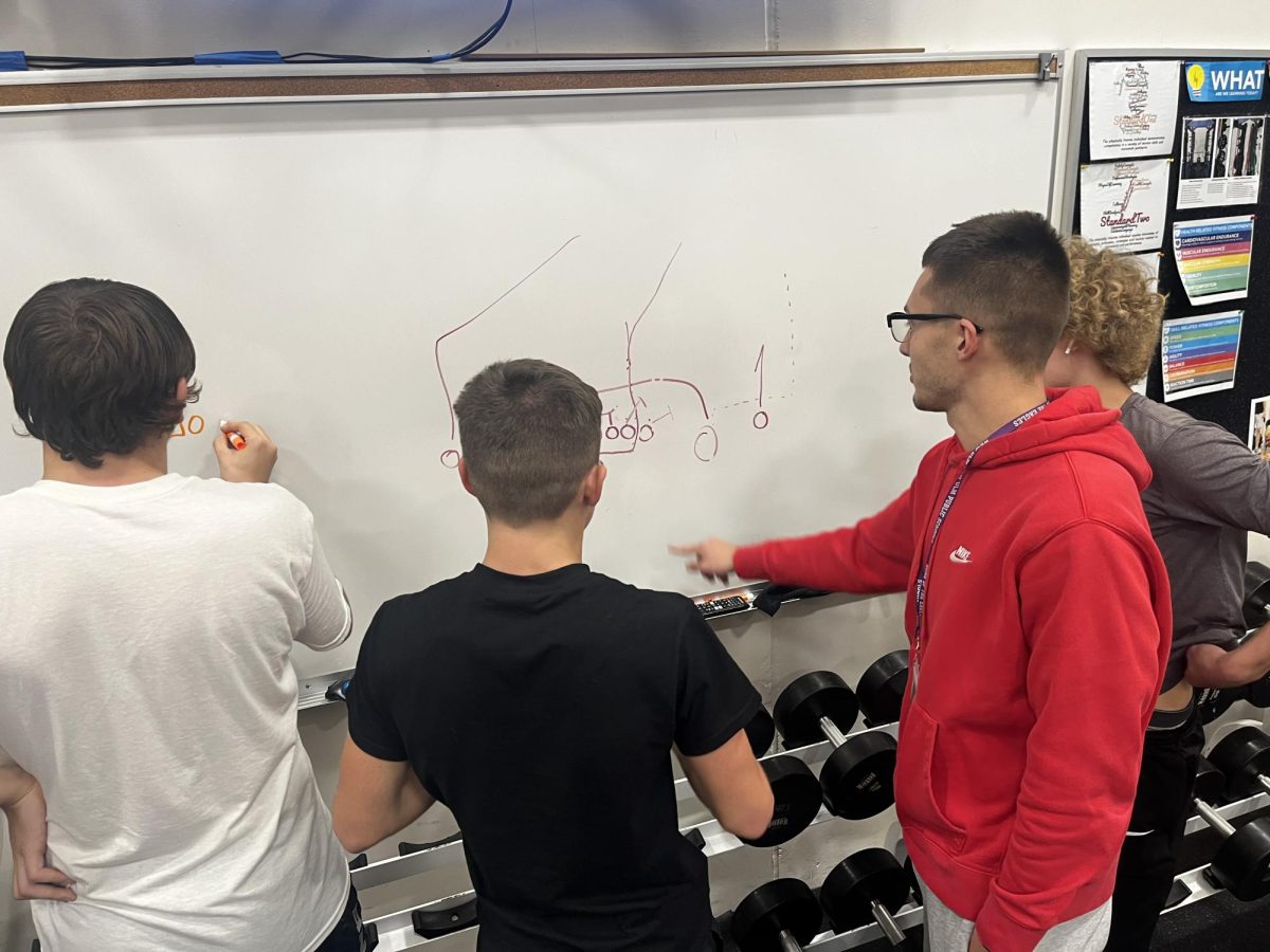 Eagles players and coaches drawing plays on the whiteboard