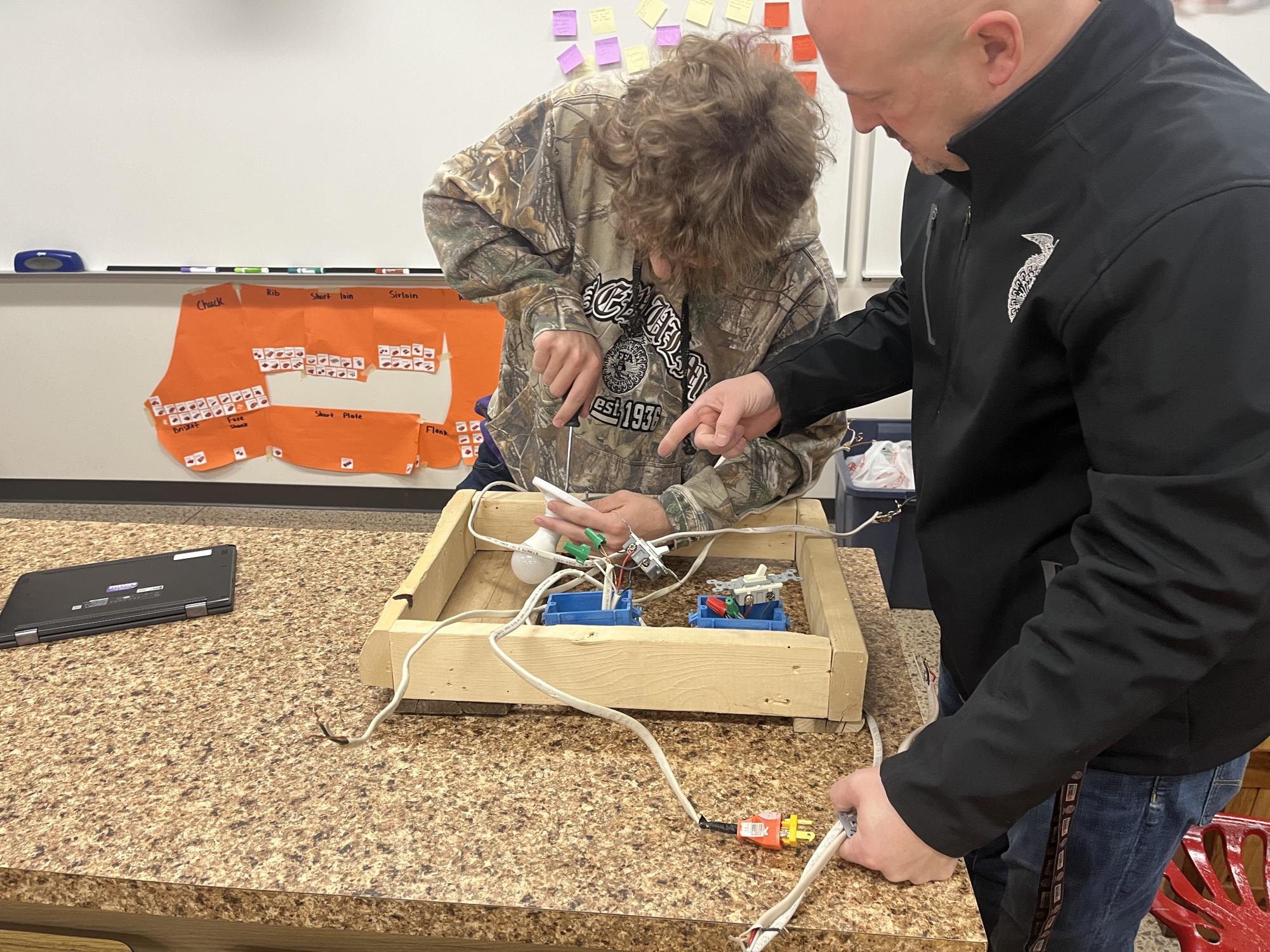 Mark Beranek learns how to wire up a two way switch while Mr. Nelson coaches him through the steps. Its actually pretty easy once you do it once or twice, Mark said.