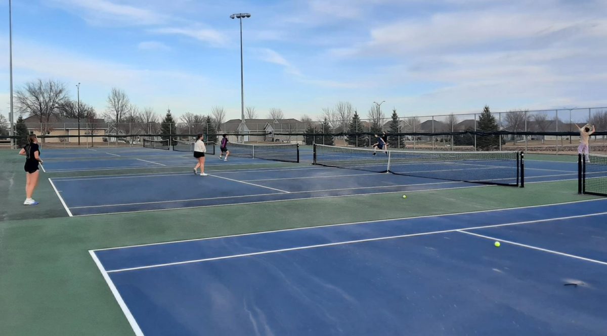 Tennis players enjoy the nets for the first time this year.
