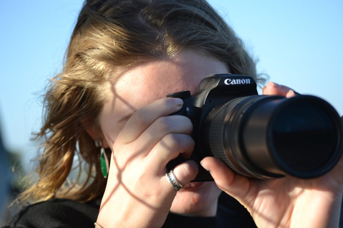 Senior Sophia Furth takes a picture of an event 