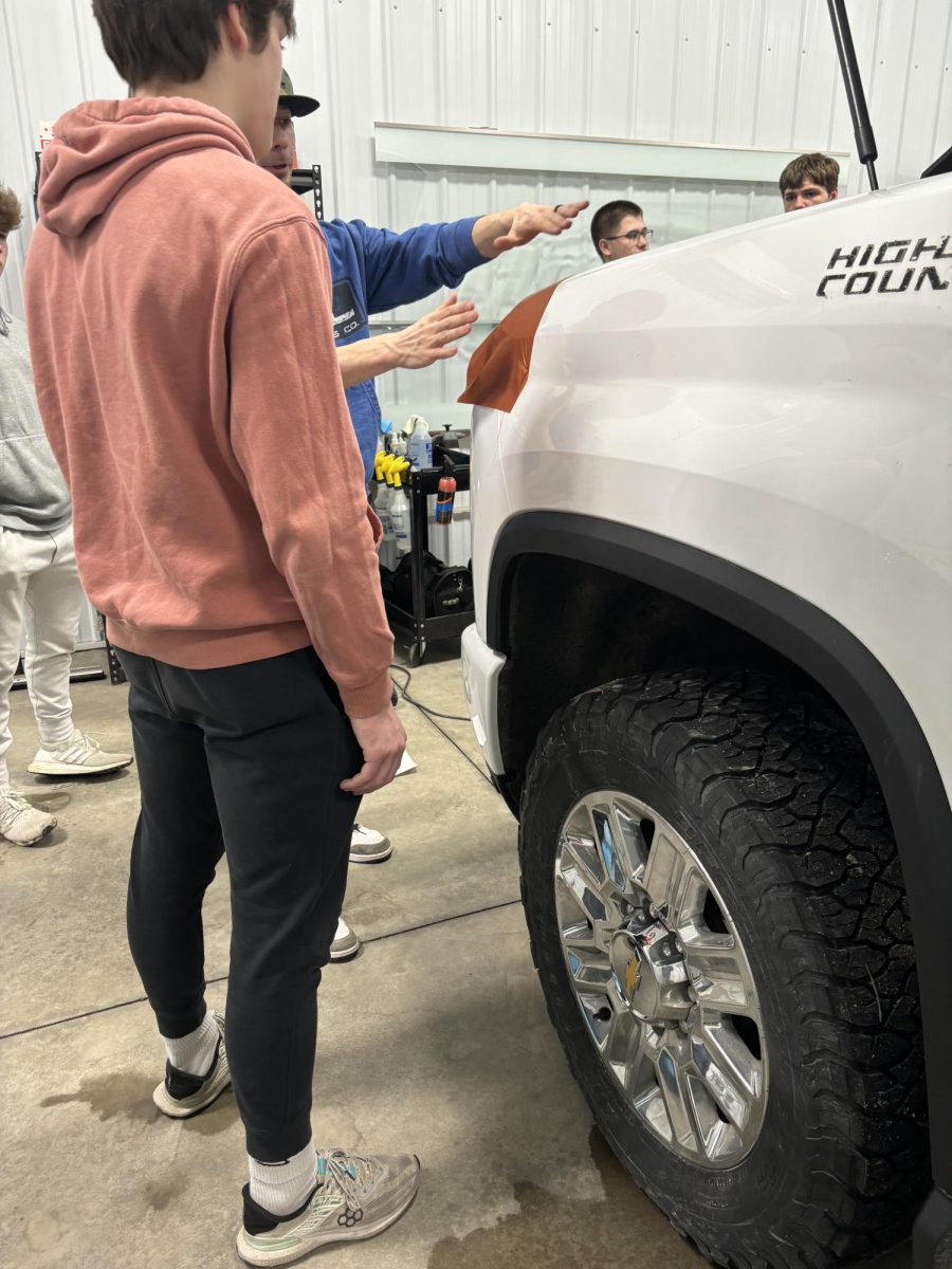 Senior Noah Engel learning how to wrap a vehicle