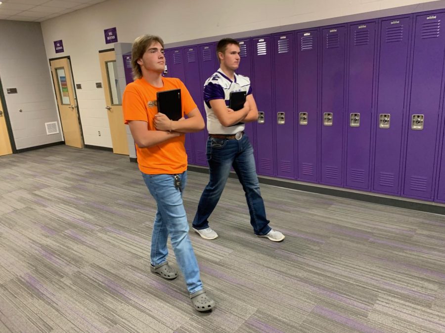 Two of New Ulm's high school students take a stroll down the hallway with the new Chromebooks in hand.