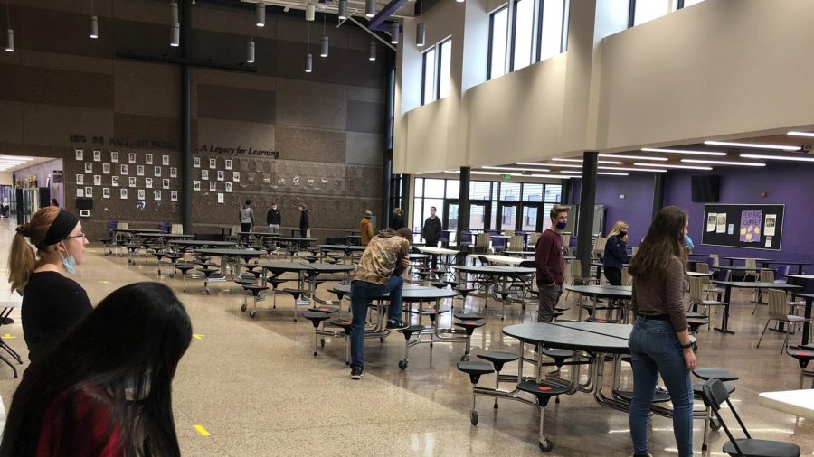 Students take a break from their masks in the cafeteria while socially distanced.