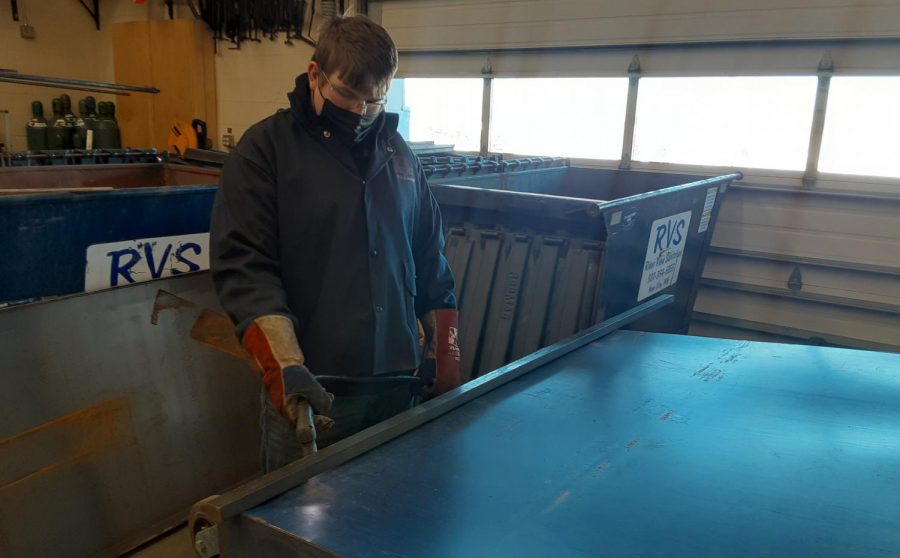 Here we see Bryce Roiger Cutting the old bottom off of a dumpster for 6th hour welding class at New Ulm High School, so it can be replaced. When interviewed, Bryce said: "That's really bright," as he was talking about the arc from the plasma cutter.