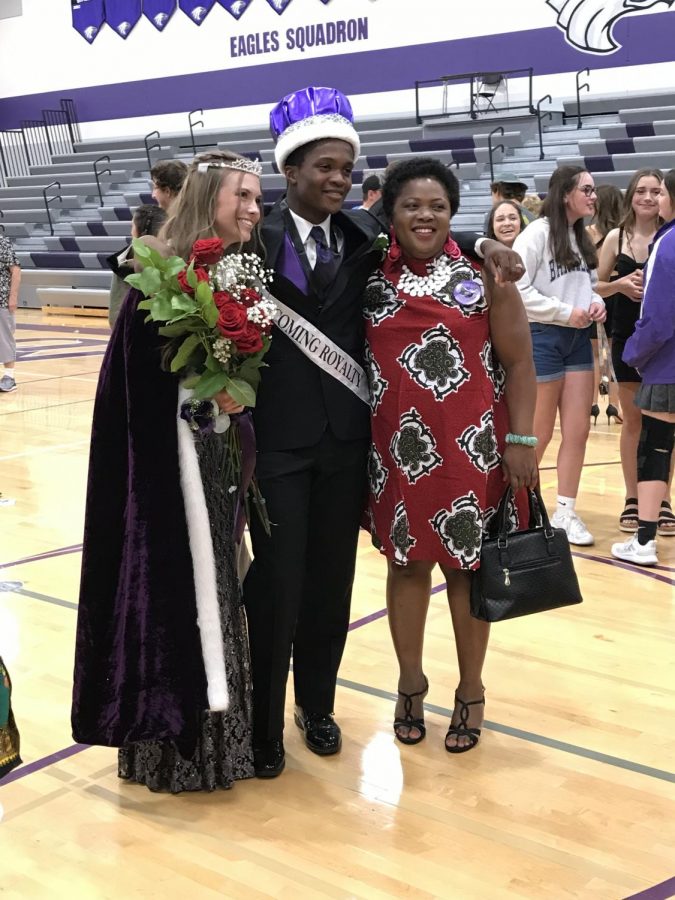 Homecoming King Macarious Amoah and Queen Makiah Otto stand with Macarious's mom for one of many pictures taken on coronation night. 