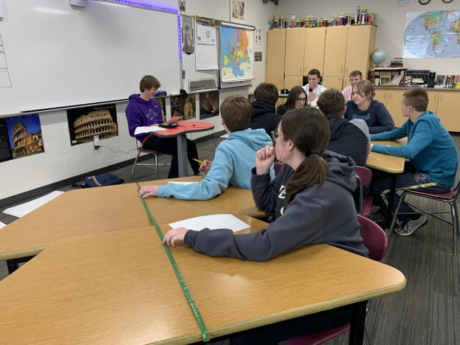 Seniors Marissa Todesco and Isaac Gieseke (front) work together to answer a question read by Freshmen Cullen Slette (purple). 