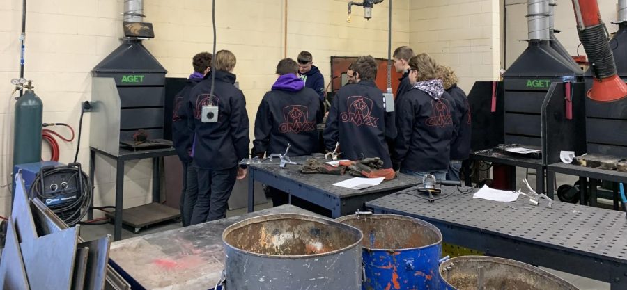 Jarrett Platz, a senior at NUHS, took a small break from 5th hour Journalism to teach Briggs class on how to properly adjust the wielding equipment and cutting metal. Sometimes its easier for other students to understand information from a fellow student, Platz said.