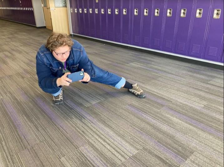 Aidan Hendrickson, a student in Mr. E's journalism class, is capturing a photo in the hallways of NUHS for a project that he is working on during Thursday afternoon's class.