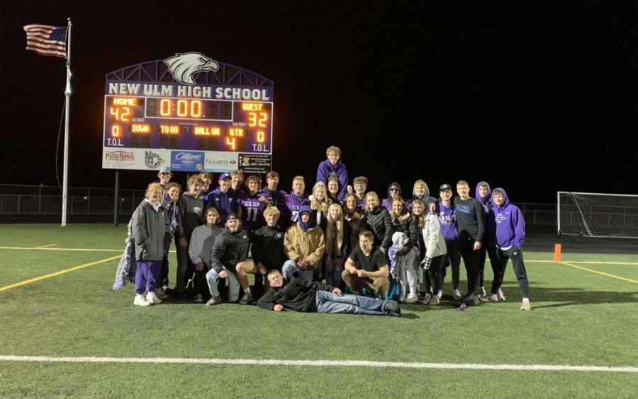 Seniors pose for picture with Senior football players in front of the scoreboard after the huge homecoming game!