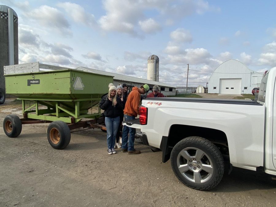The New Ulm Chapter FFA is collecting corn/bean donations for Camp True Friends in Annandale, Minnesota. Senior Andrew Meyer (right) said, "It feels good to help collect donations for a good cause." Camp True Friends is a non-profit organization that provides different programs for those with disabilities. There were over 15 FFA groups that participated in the corn drive on  Thursday, Oct. 13! Also pictured from left to right are seniors Bryn Kraus, Amelia Braulick, and Madisyn Fuchs.