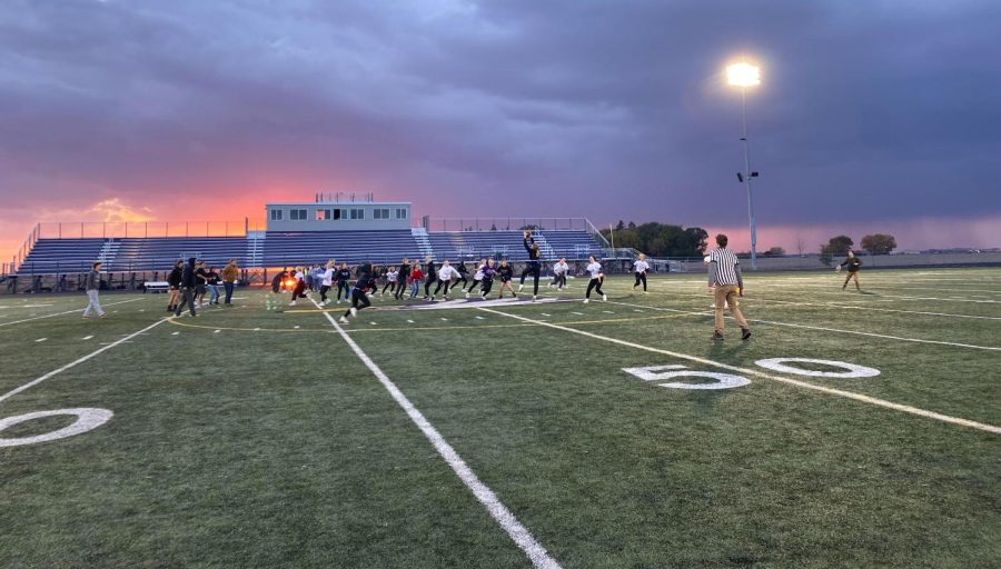NUHS junior and senior girls playing a competitive game of powder puff football on a rainy Thursday evening.