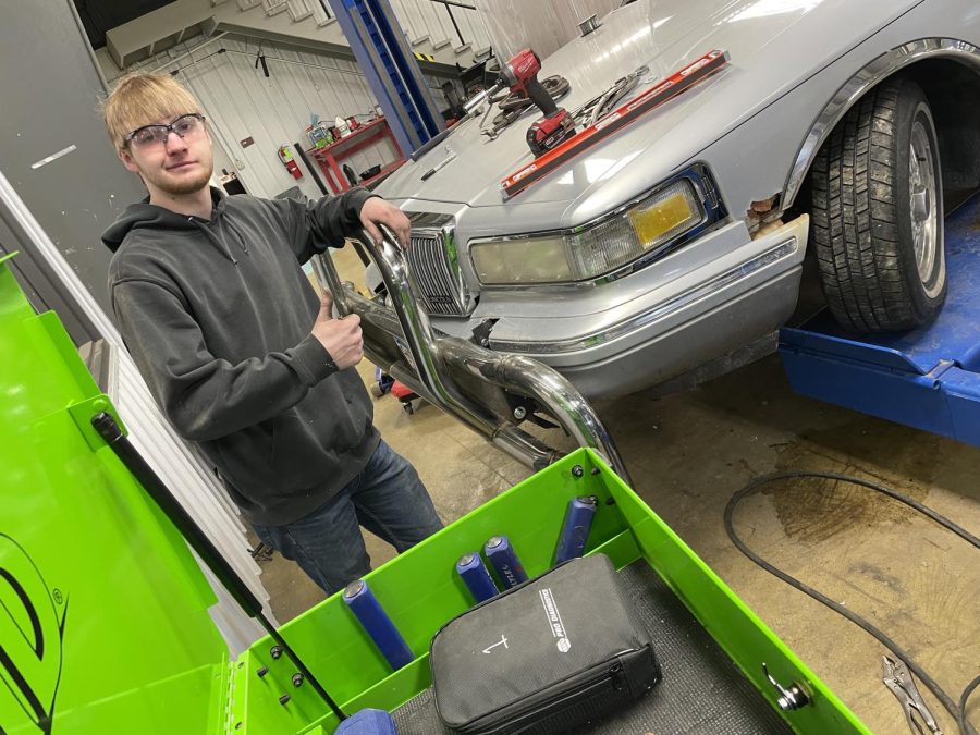 Tyler Whitney working hard to finish putting the moose bumper on the lincoln