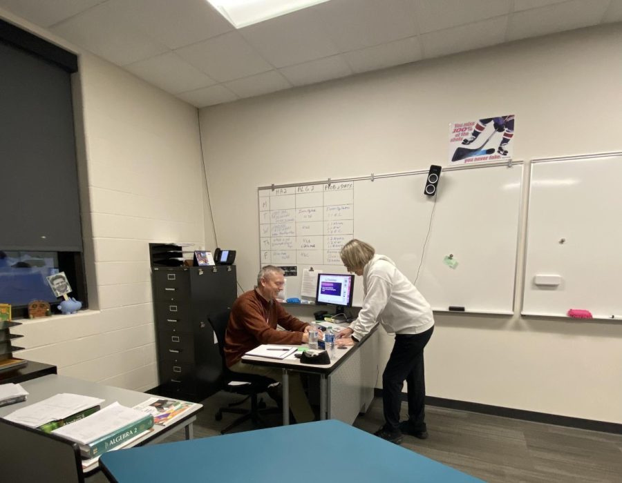 Smiling math teacher going over the day.