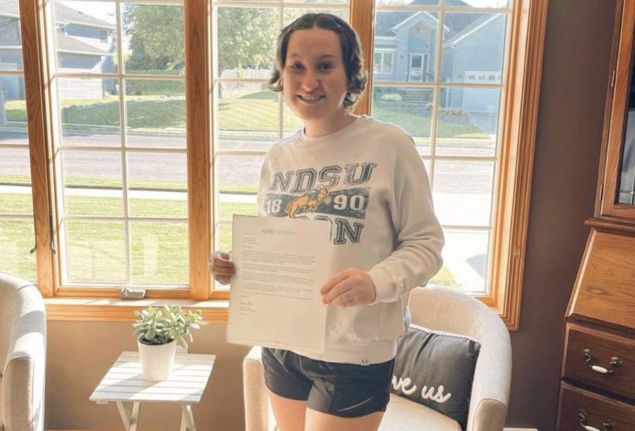 Addy Fairbairn holding her acceptance letter into her dream college!