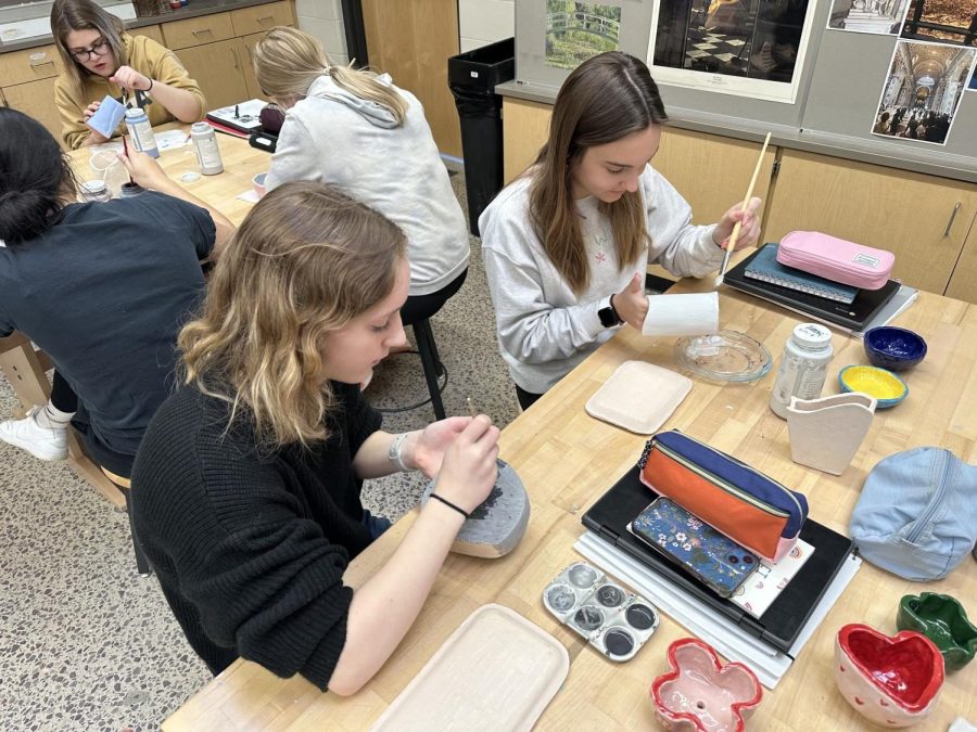 Senior Emma Miller (Left) and Senior Kate Frauenholtz glazing their slab vases.