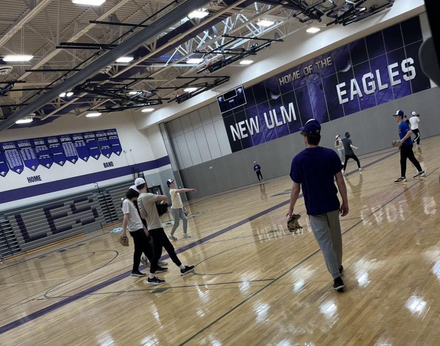 Baseball players wrap up playing catch on the first day of practice.