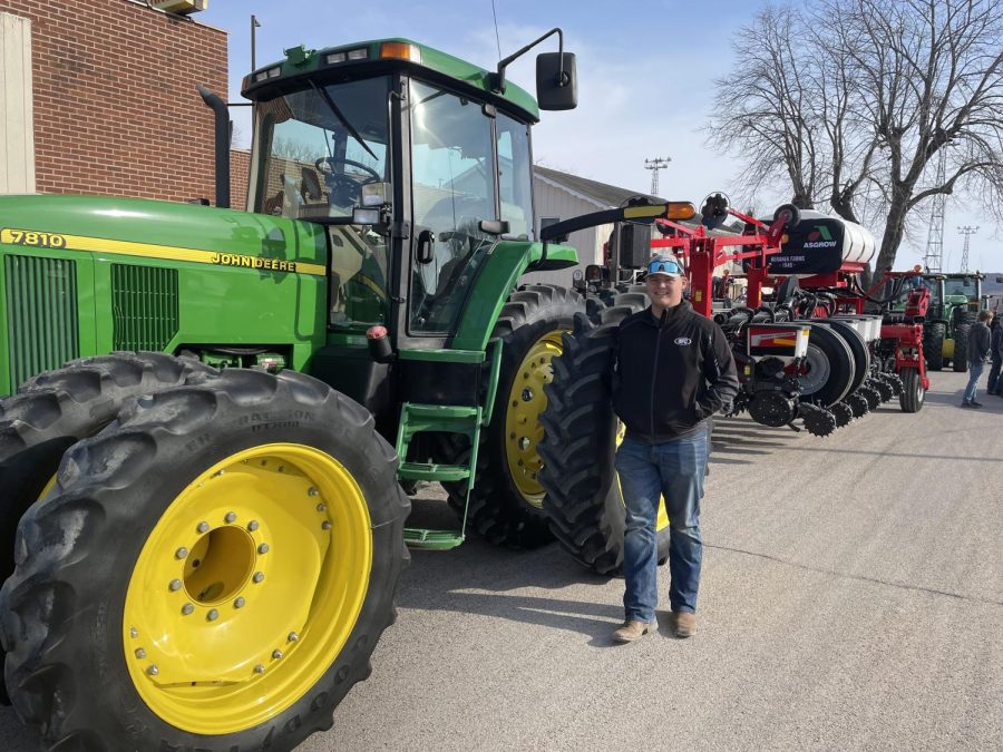 Jared Beranek next to his family's equipment waiting for his turn at the Ag Day parade.