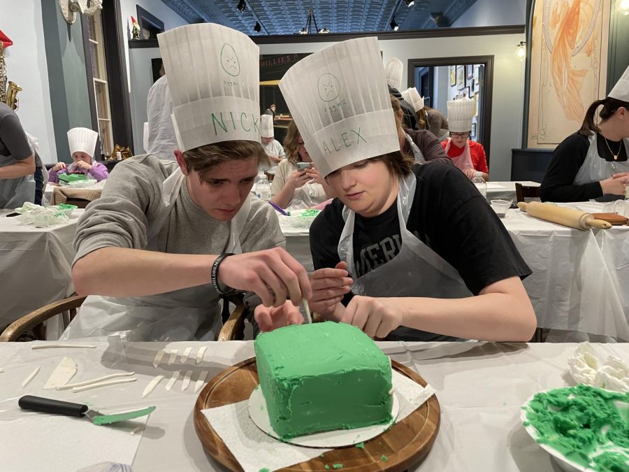 Junior Nick Vigil and college freshmen Alex Vigil putting fencing on their cake