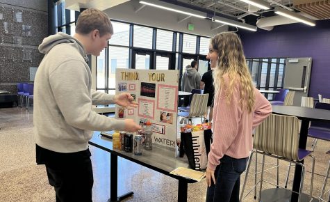 Seniors Madi Fuchs and Joe Kowalke talking at Madis Think Your Drink booth at the Health Fair. 