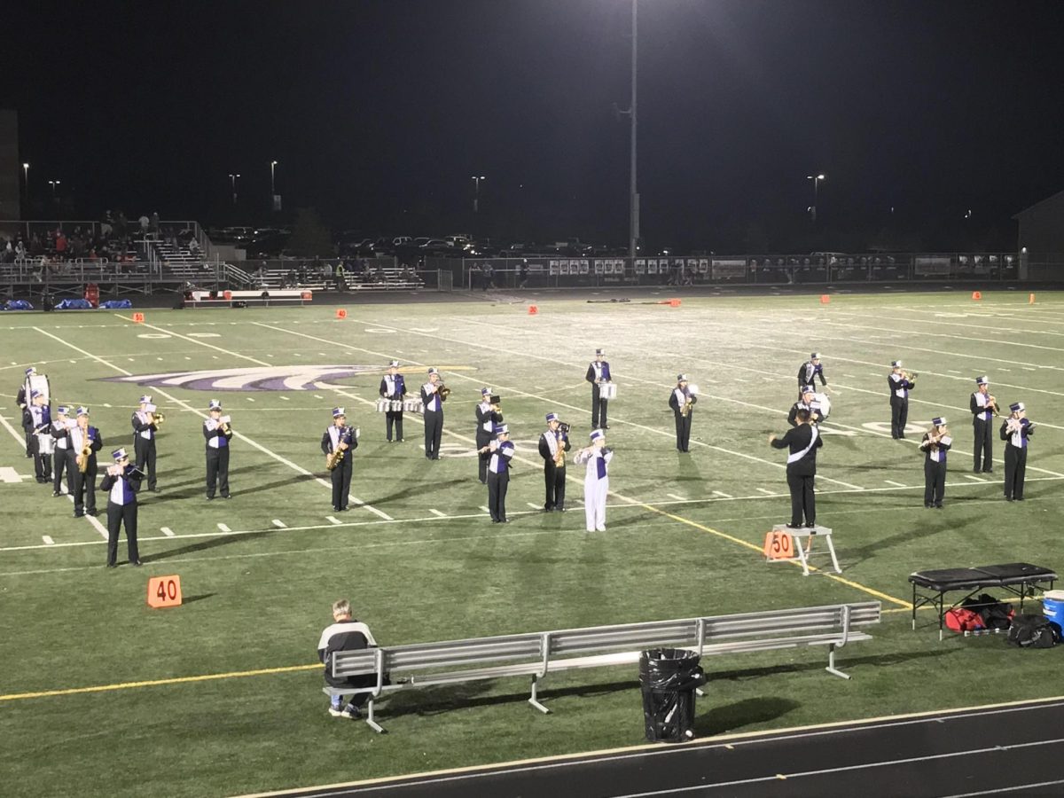 Joey Kotten elevated above the band in his Homecoming suit and sash 