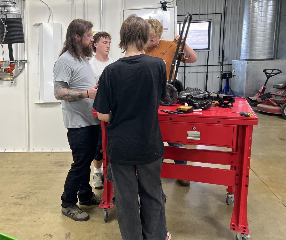 Mr Dustin helps work on  a pressure washer in small engines/ATV