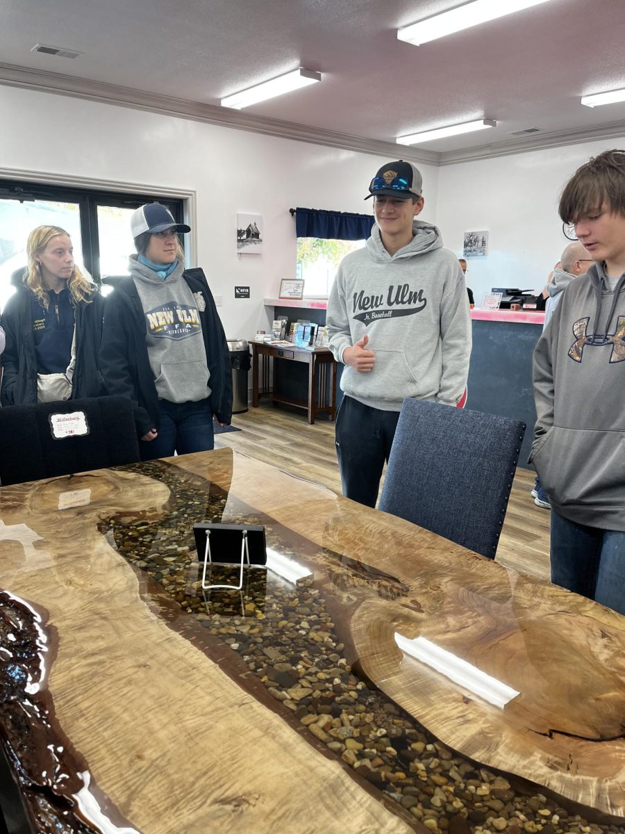 Four FFA members from Region 7 looking at a hand crafted table made by the amish.