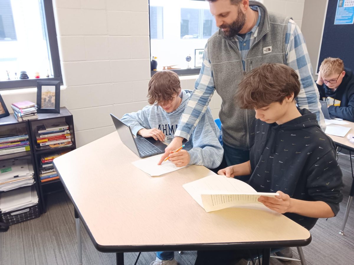 Mr.Vetter helps students in his classroom with assignments there struggling with