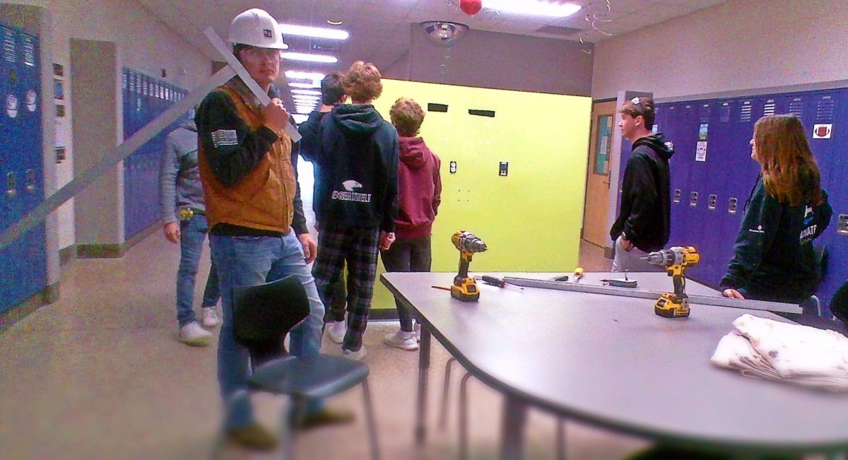 Junior Austin Nosbush poses for a picture after working on the walls. 