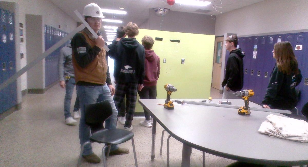 Junior Austin Nosbush poses for a picture while working in the halls by the science wing. 