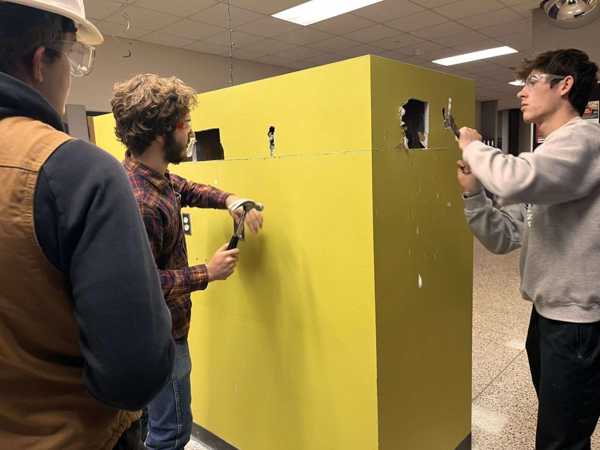 Mark Beranek (Left) and Logan Lee (Right) begin demolishing part of the wall. 