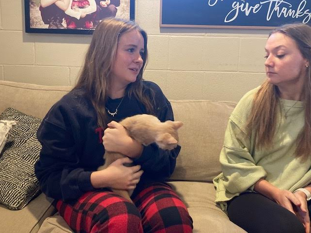 Taylor Hauenstein(left) and Ella Ahrens(right) playing with Rudy(cat) during speeches