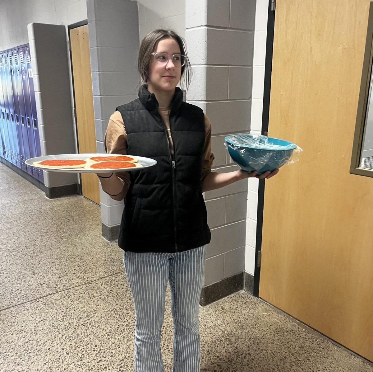 Senior claire Hoffmann holding the pizza and a bowl of homemade mozzarella. 