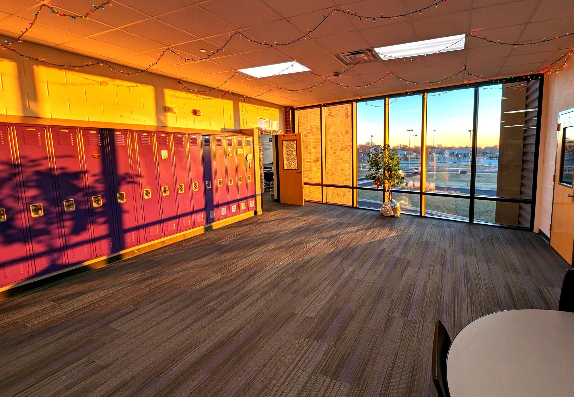 A tree decorated and lights aglow in the History wing with a warm winter sun rising in the cold.